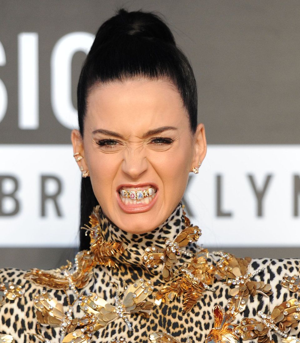 A well known pop artist proudly displaying a custom gold and diamond encrusted dental grill at a public media event