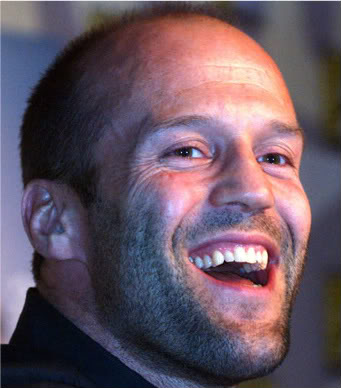 Jason Statham souriant aux éclats montrant des corridors buccaux bien remplis