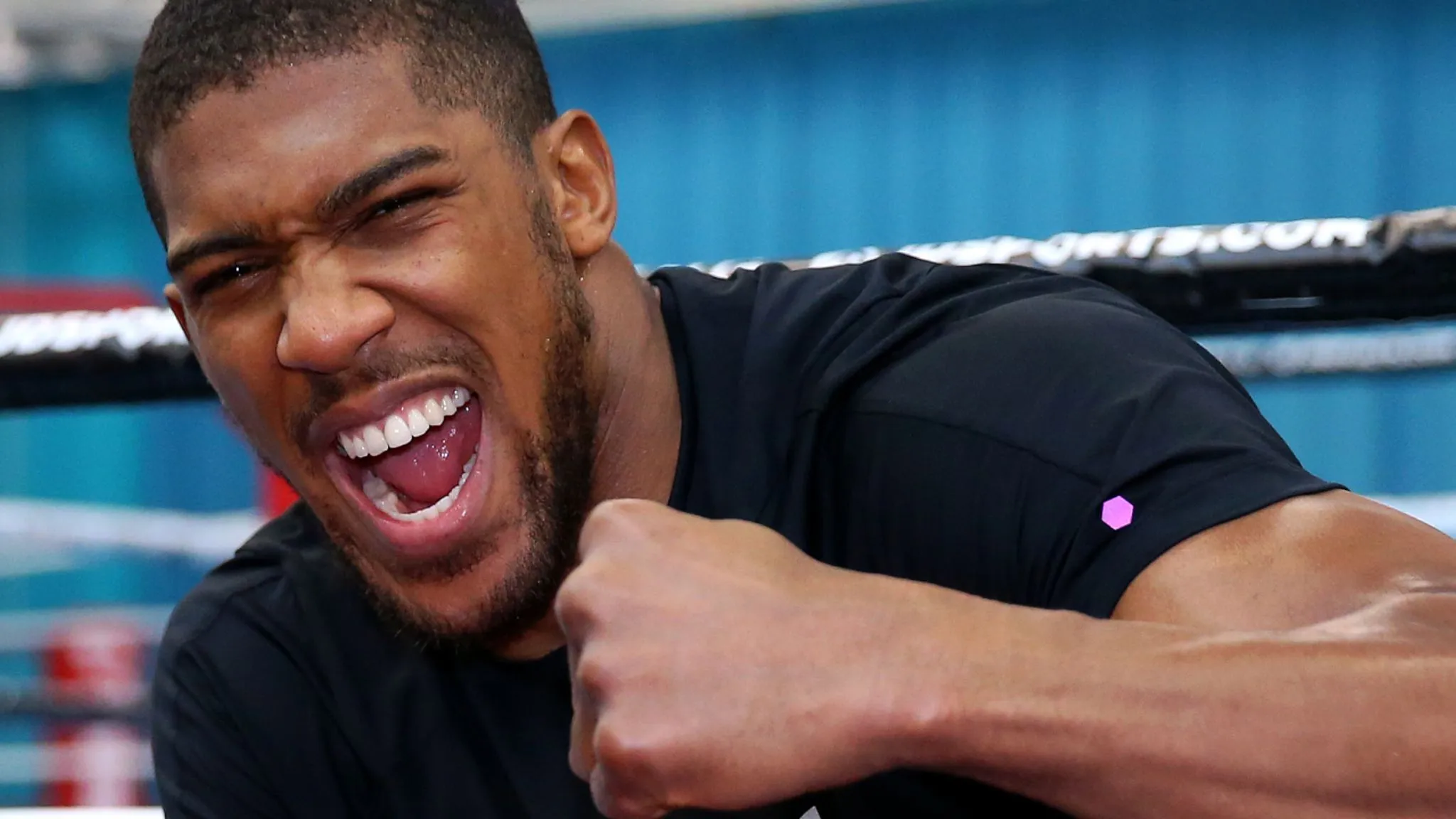 Portrait d'Anthony Joshua sur le ring de boxe montrant son sourire