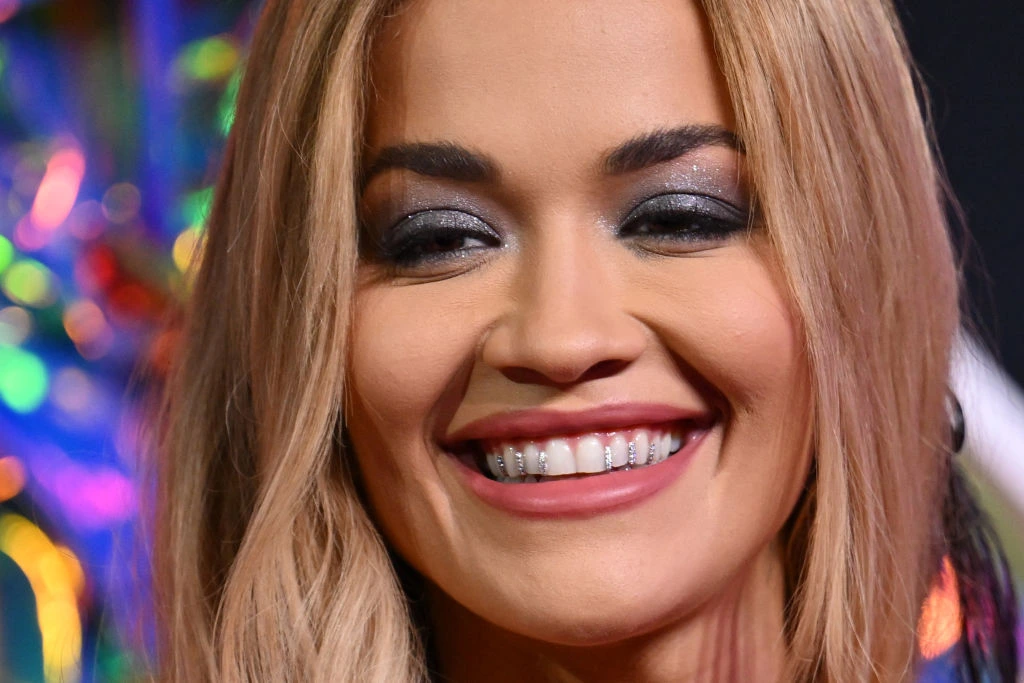 Dents de Rita Ora avant et apres comparaison montrant l'evolution naturelle du sourire